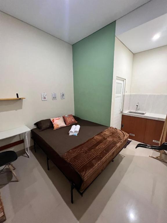 a bedroom with a large bed and a sink at Tuwin Guest House Syariah in Yogyakarta