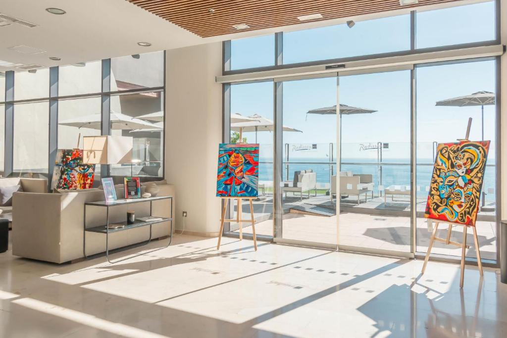 a room with two paintings on display in front of windows at Radisson Blu Resort Gran Canaria in La Playa de Arguineguín