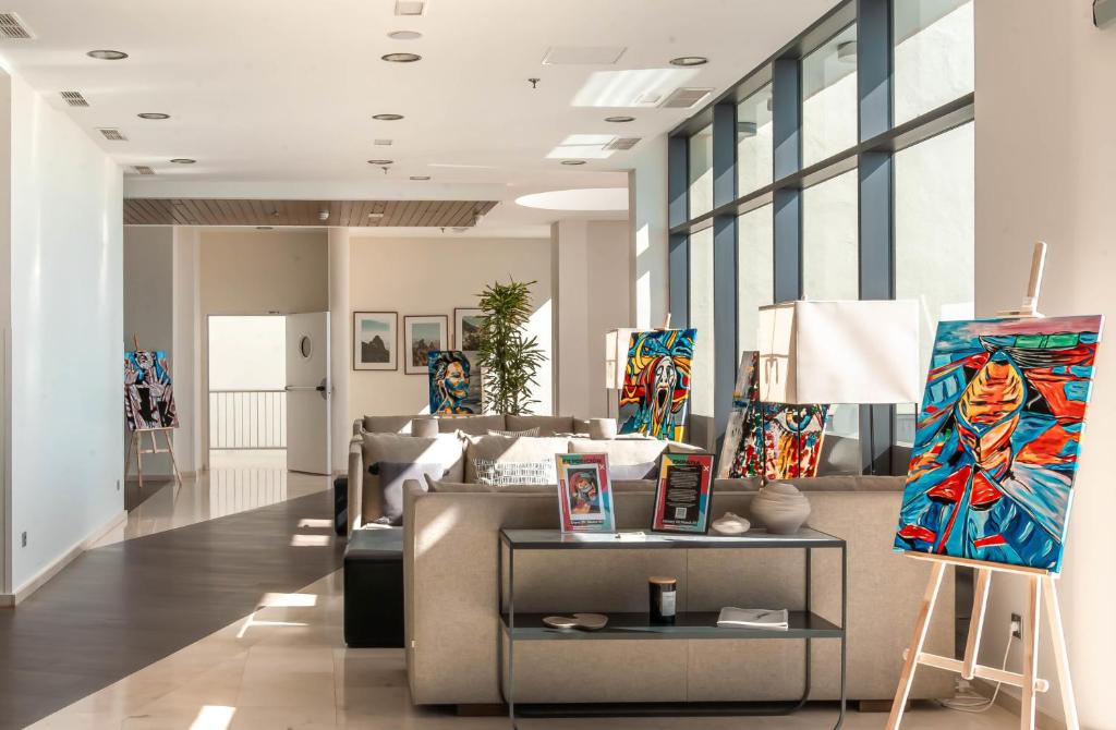 a room with a couch and a table with paintings at Radisson Blu Resort Gran Canaria in La Playa de Arguineguín