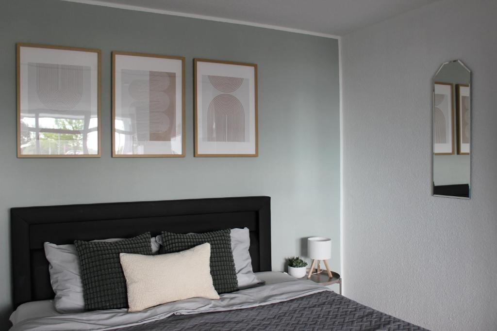 a bedroom with a bed with three mirrors on the wall at Ostseeferienparadies Heiligenhafen in Heiligenhafen