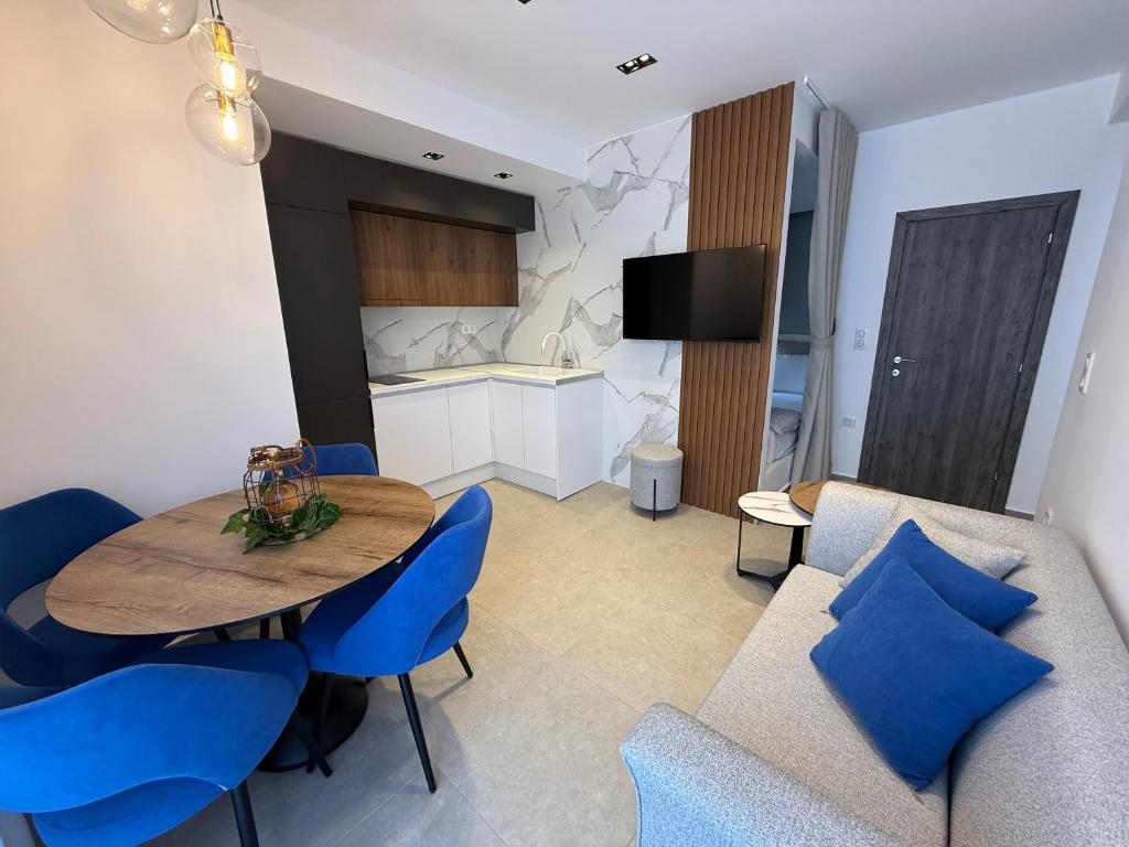a kitchen and dining room with a table and blue chairs at G&S Dionisiou Apartment in Paralia Dionysiou