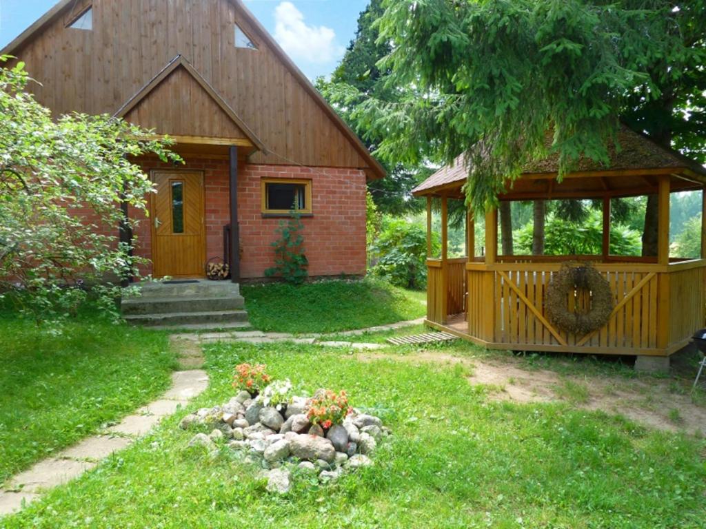 ein kleines Haus mit einem Pavillon im Hof in der Unterkunft Brīviņi in Jaunjelgava