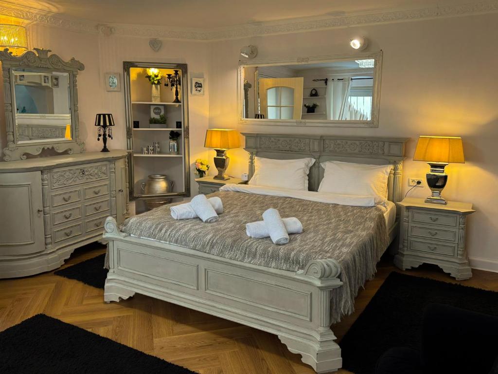 a bedroom with a large bed with two towels at Hidden Hollow - Ultra Central in Braşov