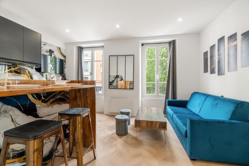 un salon avec un canapé bleu et une table dans l'établissement Appartement Neuf et Lumineux aux Portes de Paris, à Saint-Maurice