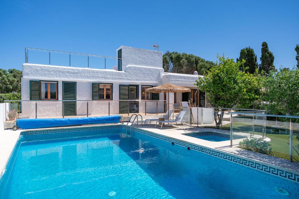 una casa con piscina di fronte a una casa di Villa Bini Ezolea a Binibeca