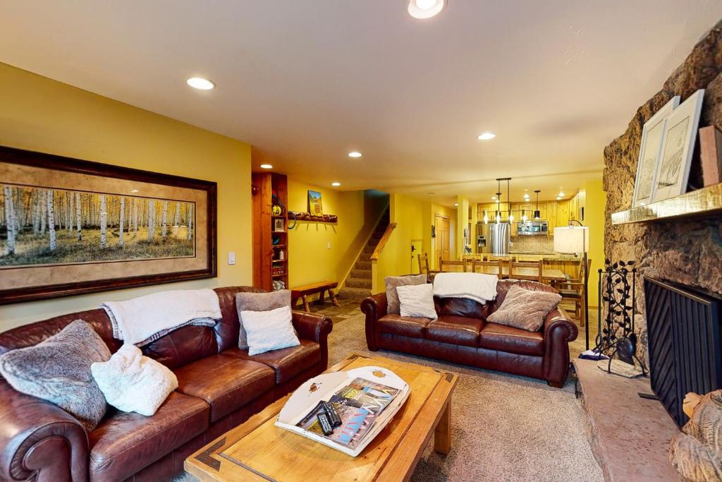 a living room with leather couches and a fireplace at Beaver Creek West 26 in Avon