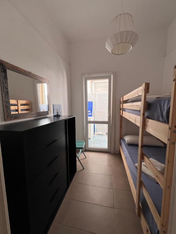a bedroom with two bunk beds and a mirror at VIRVIT CASA VACANZE in Porto Cesareo
