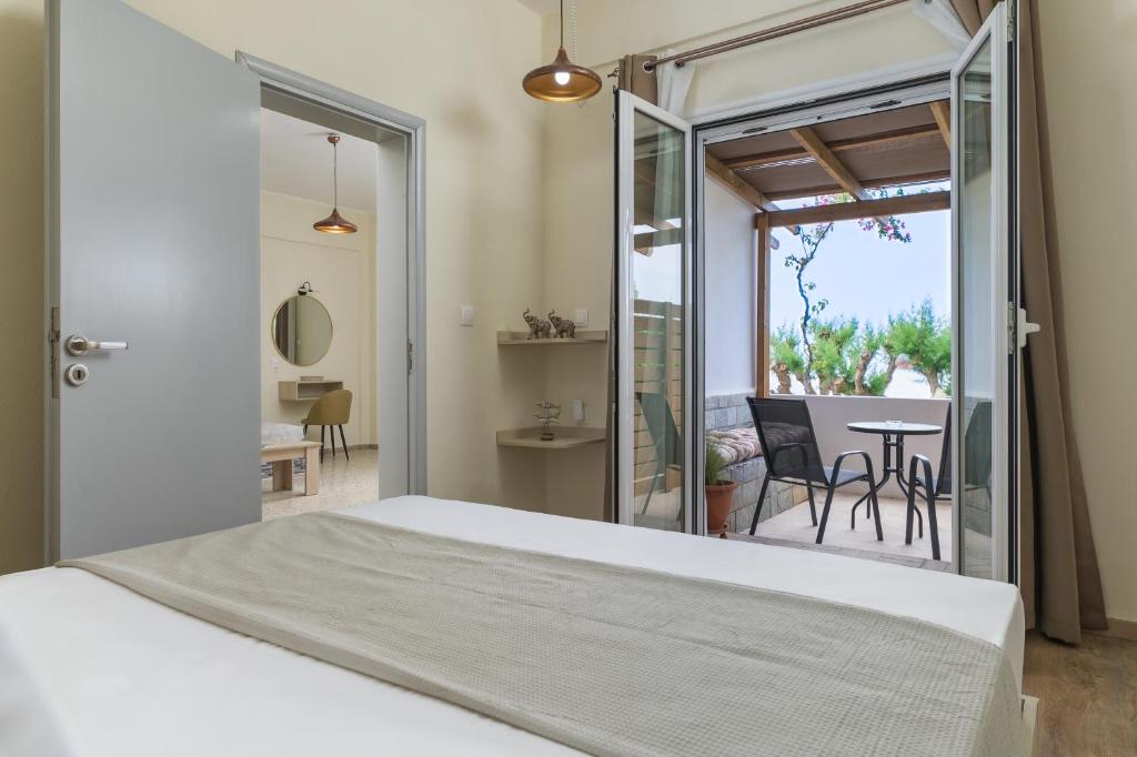 a bedroom with a bed and a balcony with a table at SOLE e MARE A1 in Koutsourás