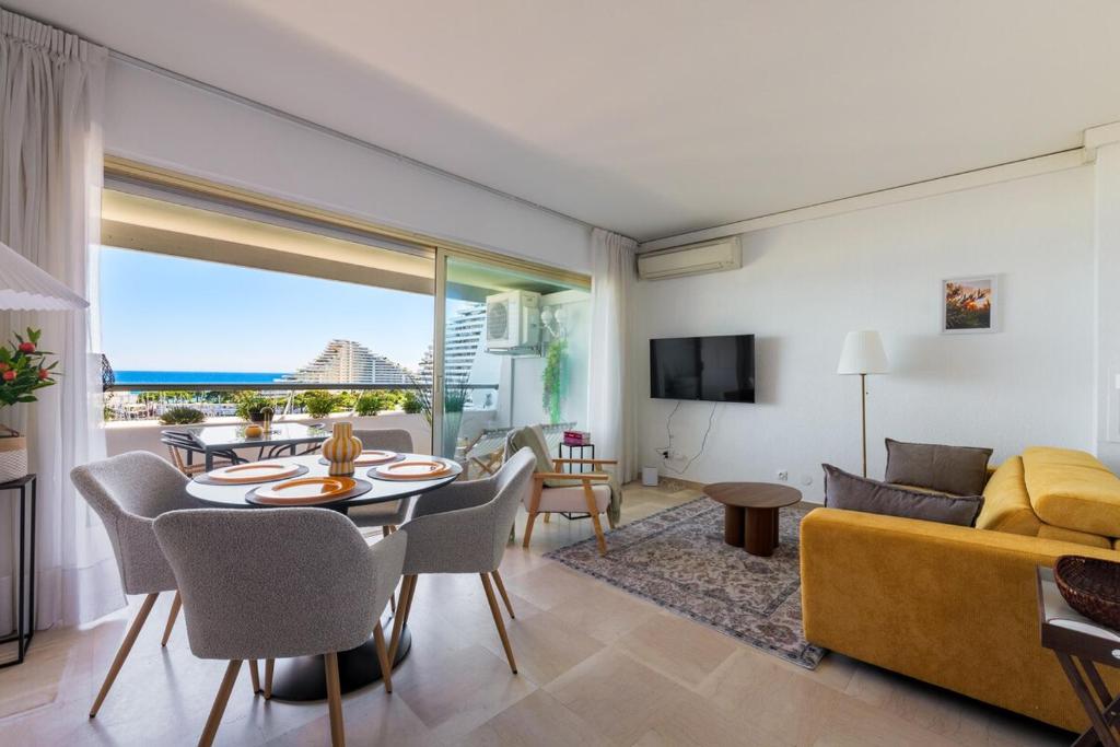 un salon avec un canapé jaune et une table dans l'établissement Charmant 2 pièces - Vue Mer - Marina Baie des Anges, à Villeneuve-Loubet