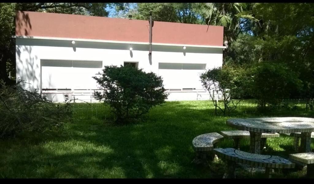 a building with a picnic table in a yard at Casa de Campo Brandsen - Quinta La Mandarina in Brandsen