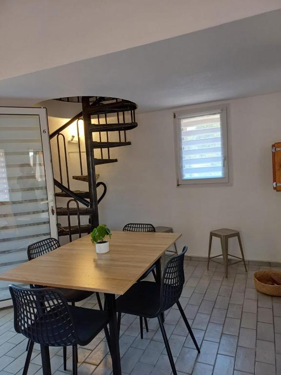 une salle à manger avec une table et des chaises en bois dans l'établissement Mini villa résidence RIVIERA avec piscine proche Porto Vecchio, à Lecci