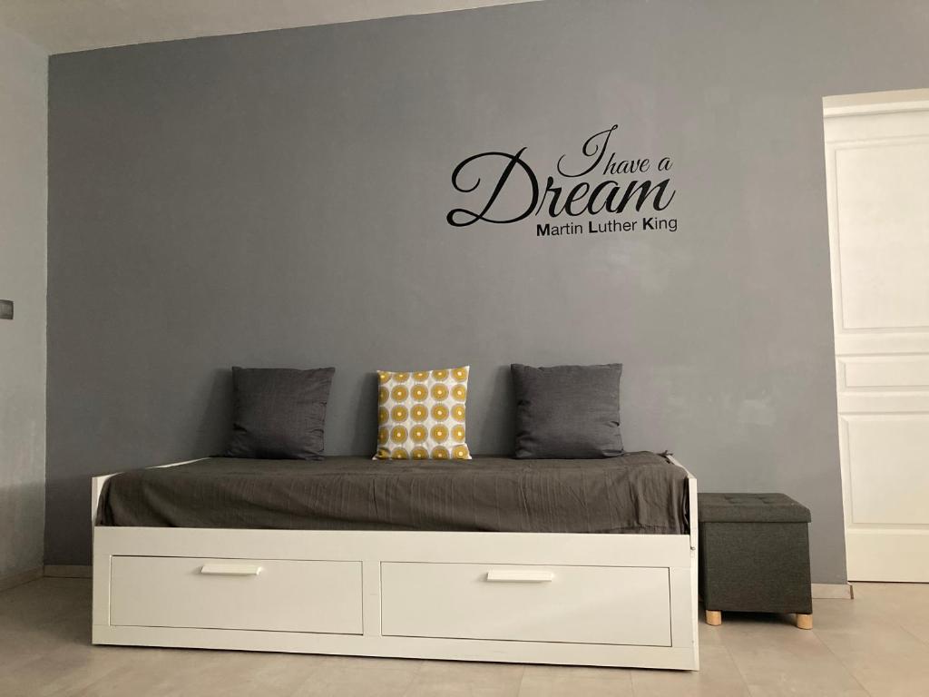 une chambre avec un lit avec un panneau « Have a dream » sur le mur dans l'établissement COLORS by Reine du Sud, proche des Grands Buffets, à Narbonne