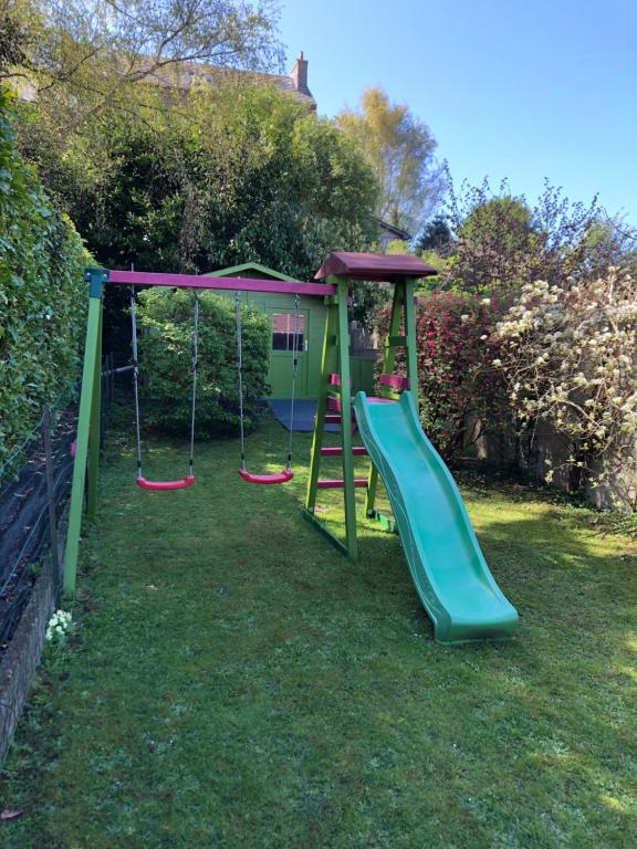 a playground with a slide in the grass at Au galet bleu in Dieppe
