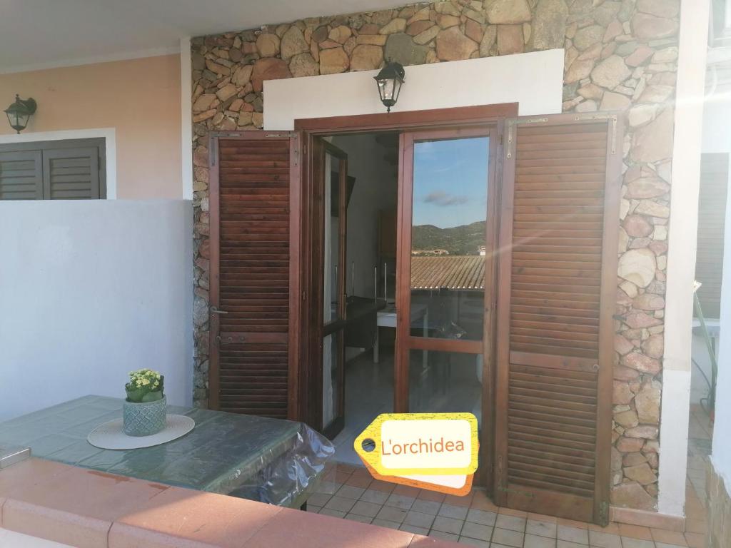 a house with a glass door and a patio at Casa Orchidea in Villasimius