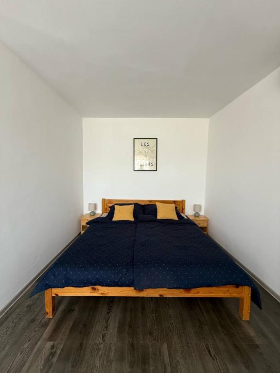 a bedroom with a bed with a blue comforter at Rose 14 Food & Room in Nemesvámos