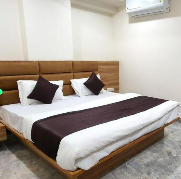 a bedroom with a large bed with white and black pillows at The Gravity Hotel in Ahmedabad