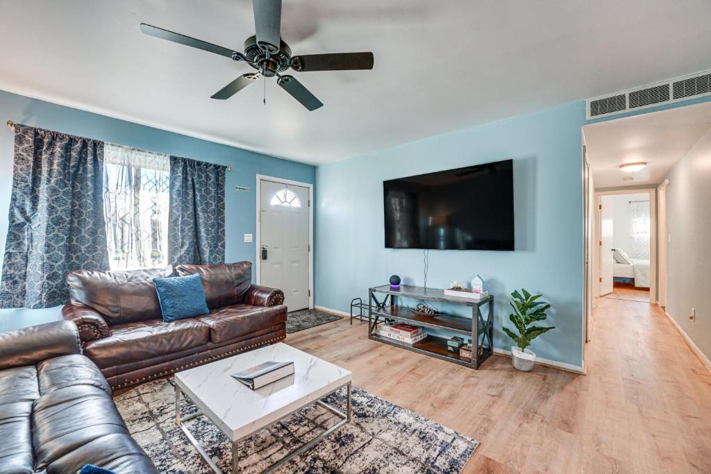 a living room with a leather couch and a flat screen tv at Charming Retreat in Ann Arbor in Ann Arbor