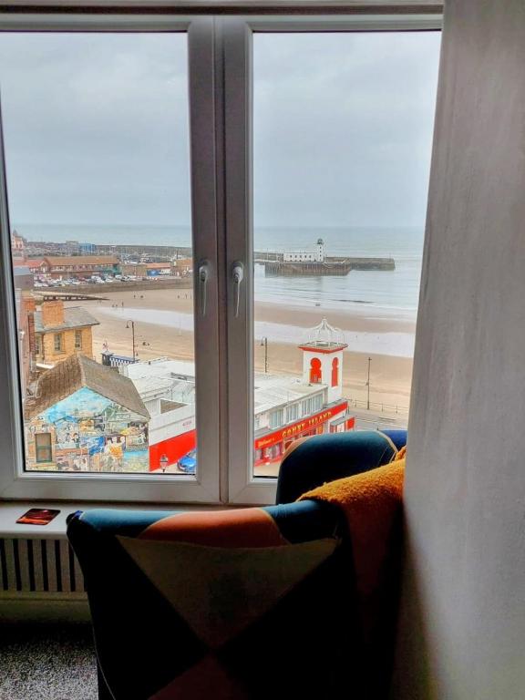 a room with a window looking out at a beach at 5 Prospect Place - 2nd floor Dream View in Scarborough