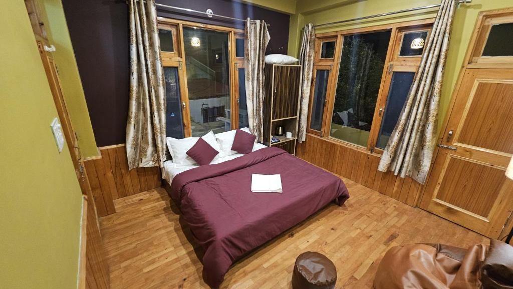 a bedroom with a bed with a purple comforter at Kintsugi by Oztel in Kasol