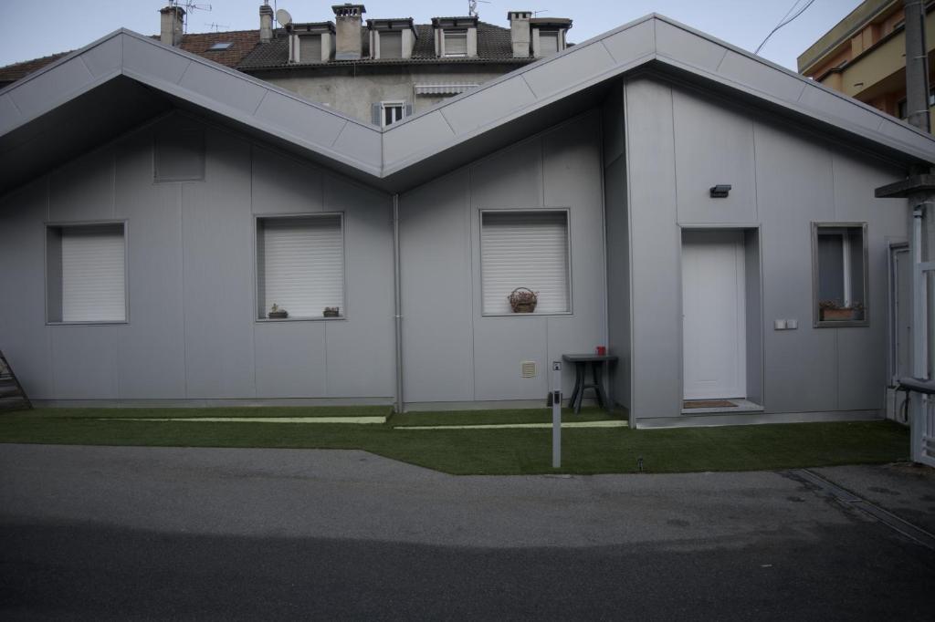 a white house with two windows and a yard at Casa Cortina in Domodossola