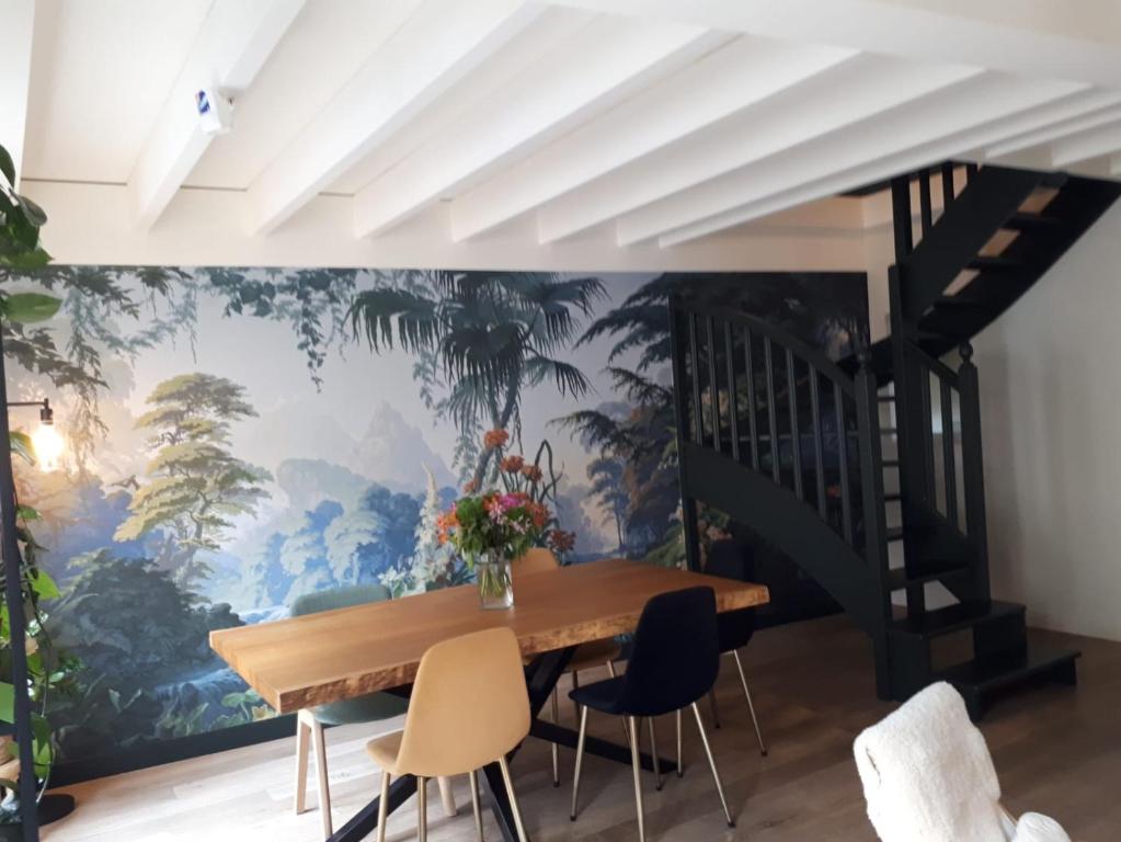 une salle à manger ornée d'une fresque murale représentant des arbres dans l'établissement Charme et confort au cœur de Versailles, à Versailles