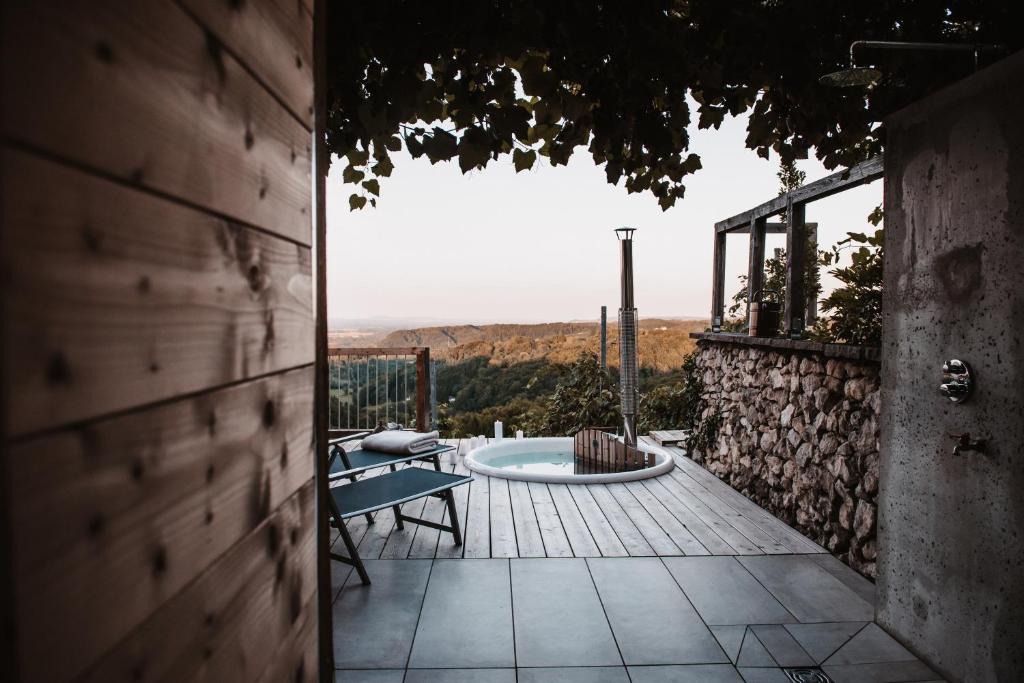 a patio with a hot tub and a table and chairs at Ferienhaus Am Grassnitzberg 18 in Straß in Steiermark