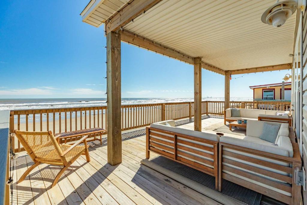 a porch with a couch and a chair on the beach at Direct Beach Access Beachfront in Freeport