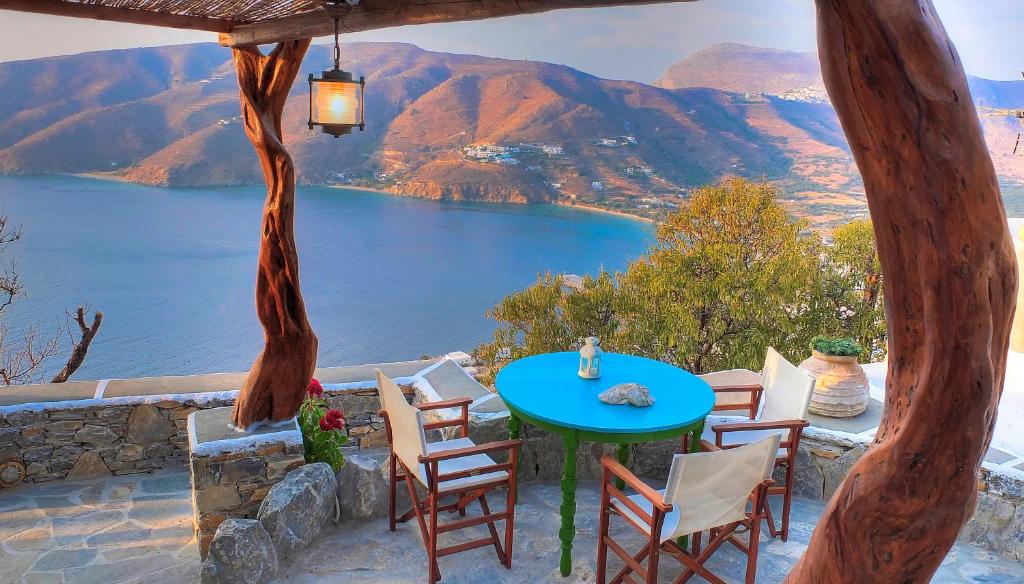 a table and chairs on a balcony with a view of a lake at Pano Gitonia in Aegiali
