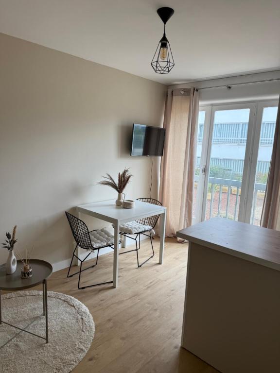 un salon avec une table et des chaises et une cuisine dans l'établissement Charmant studio avec piscine, à La Grande Motte