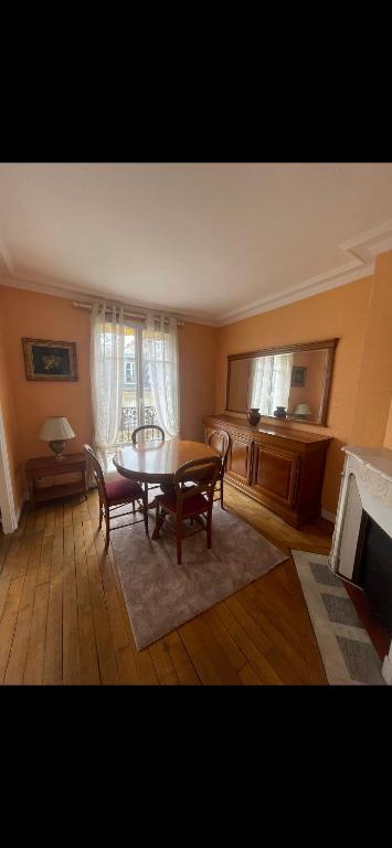 a living room with a table and chairs and a television at Appartement avec Terrasse 14 ème in Paris