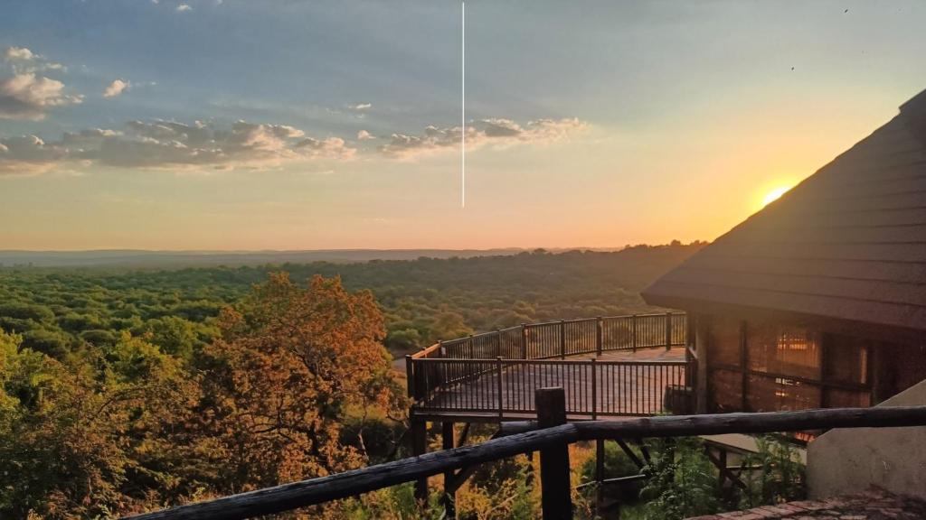 a view of the sunset from the balcony of a house at Monateng Safari Lodge in Wallmannstal