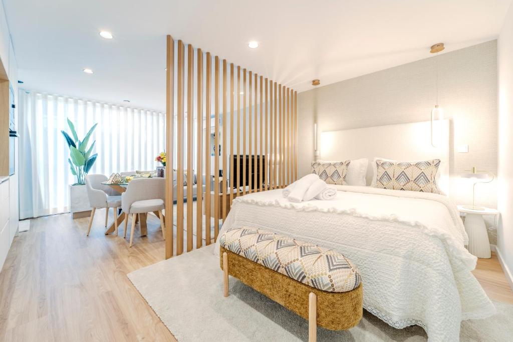 a bedroom with a large bed and a dining room at Seventy Four House in Braga