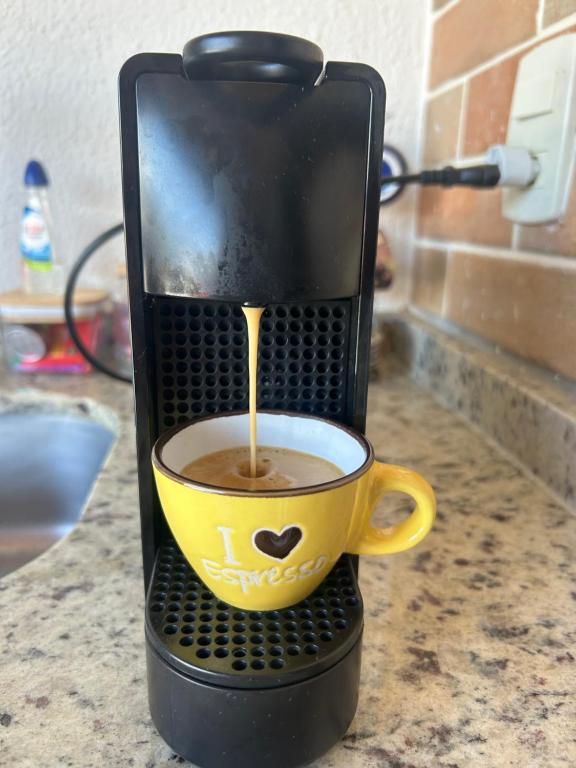 a coffee maker is making a cup of coffee at Apartamento em Praia do Francês in Praia do Frances