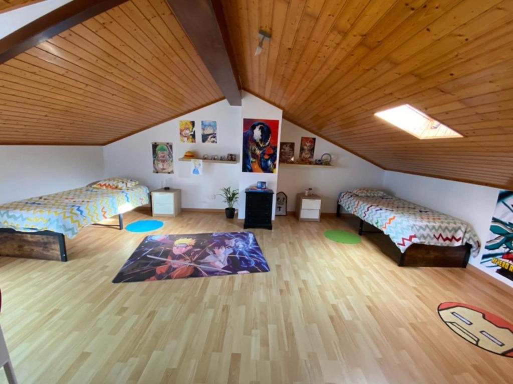 ein Zimmer mit zwei Betten und einer Holzdecke in der Unterkunft MAISON FAMILIALE ENTRE MER ET MONTAGNE Lisbonne in São Bartolomeu