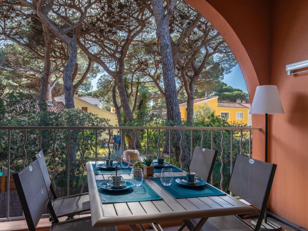 une table et des chaises sur un balcon arboré dans l'établissement Apartment Les Maldives-2 by Interhome, à Hyères