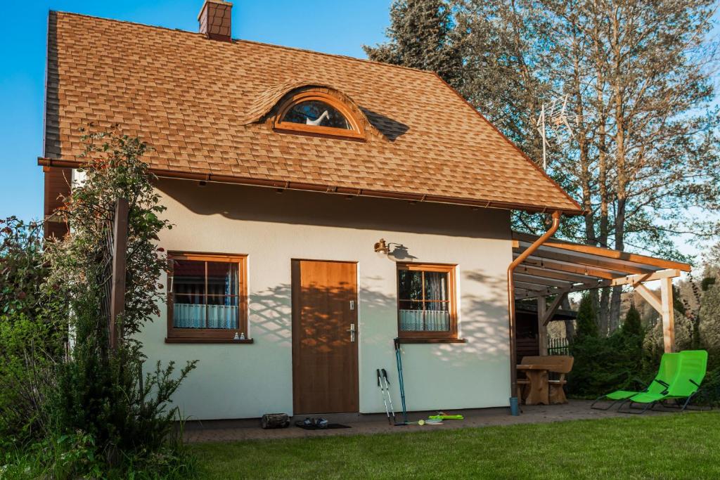 une petite maison blanche avec un toit marron dans l'établissement Słowicze Gniazdo Kopalino, à Kopalino
