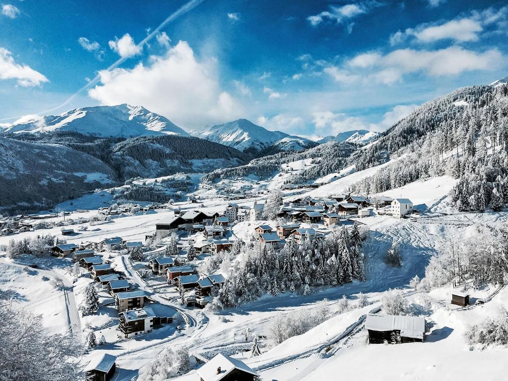 un pueblo cubierto de nieve con montañas en el fondo en Apartment Apt B 096 by Interhome, en Disentis