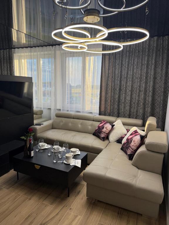 a living room with a couch and a chandelier at Sapore Dream STUDIO 3 in Opole
