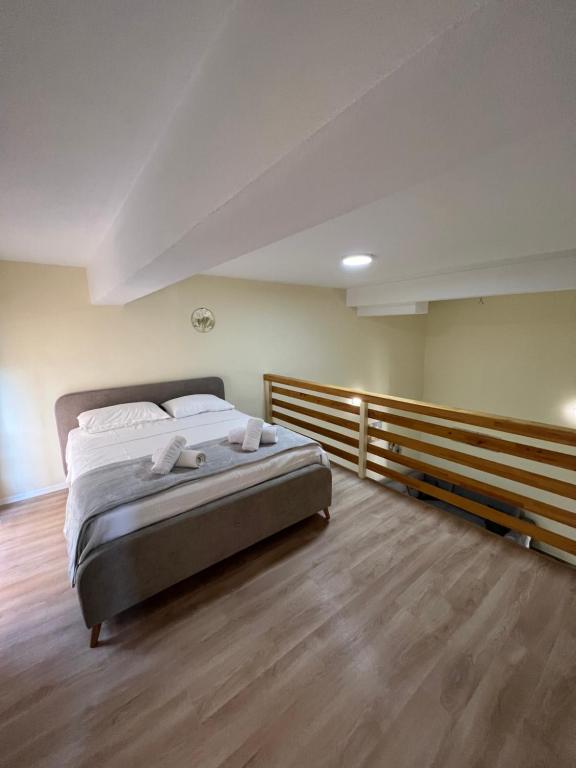 a bedroom with a bed and a wooden floor at Saranda View Apartments in Sarandë
