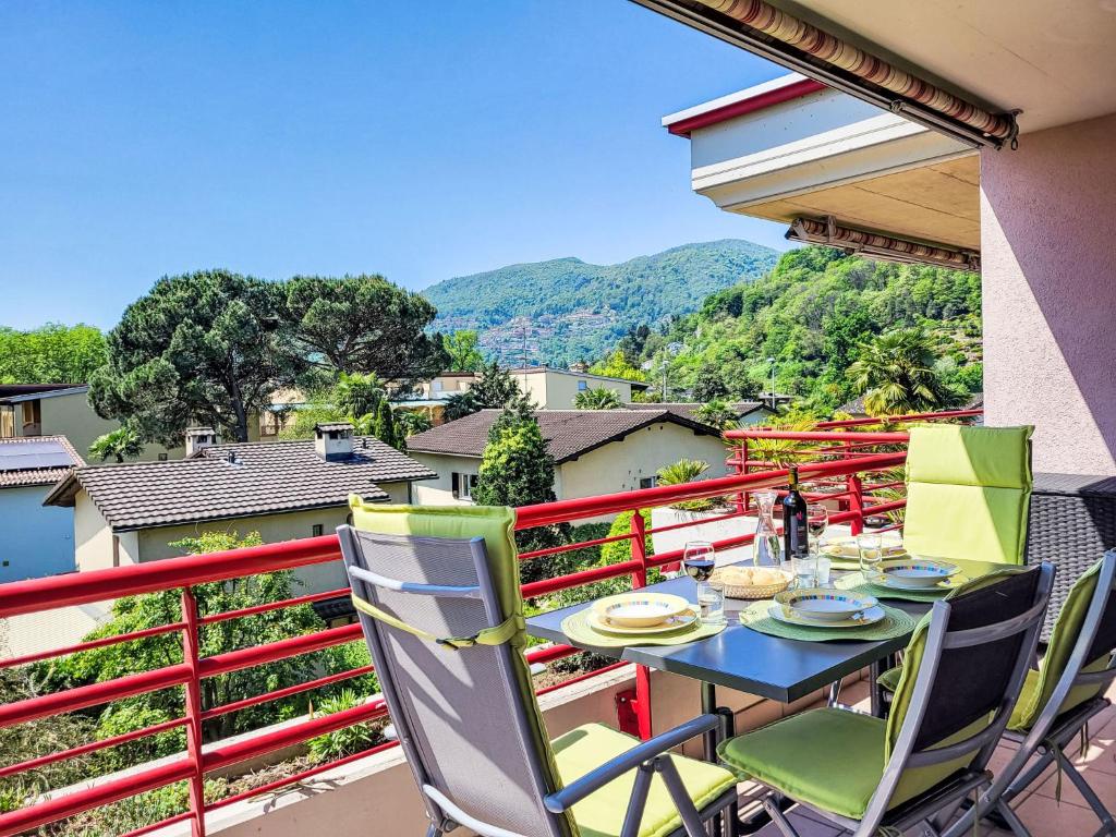a table and chairs on a balcony with a view at Apartment Caslago by Interhome in Caslano