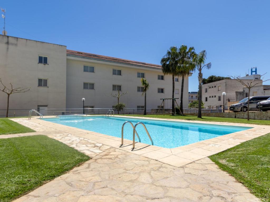 a swimming pool in front of a building at Apartment Merida by Interhome in Les Cases d'Alcanar