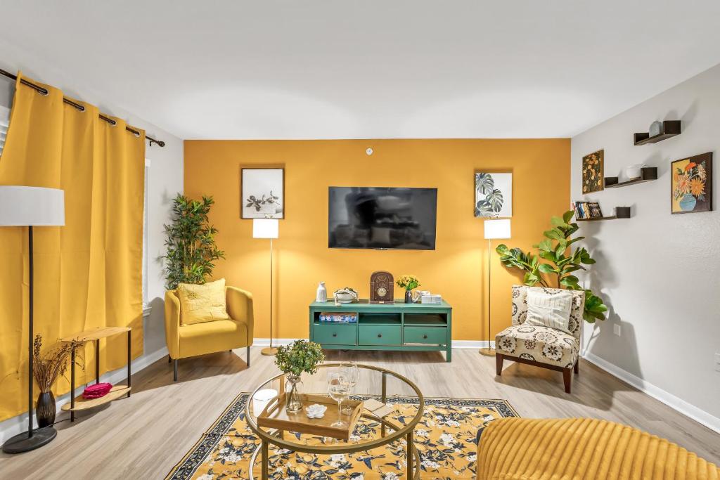 a living room with yellow walls and a table and chairs at Casa Marigold ATX - Cozy Stay - Near DT & Airport in Austin