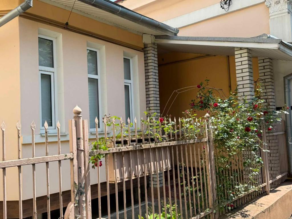 a fence in front of a house with flowers at Затишний Дім in Chernivtsi