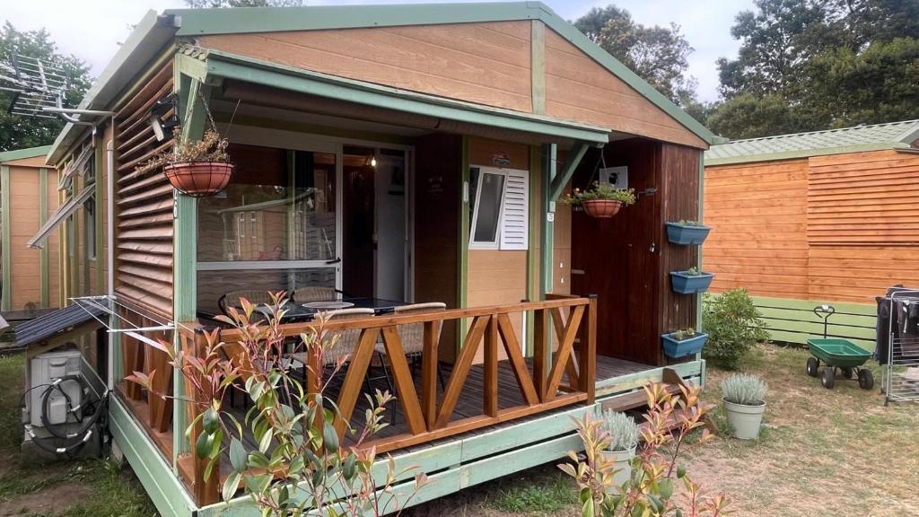 une petite maison avec un porche et une terrasse dans l'établissement Chalet climatisé en Haute-Corse 500m plage - camping Marina di Sorbo, à Sorbo-Ocagnano