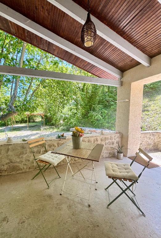 d'une terrasse avec une table, des chaises et une lampe pendant. dans l'établissement Le petit chalus, à Forcalquier