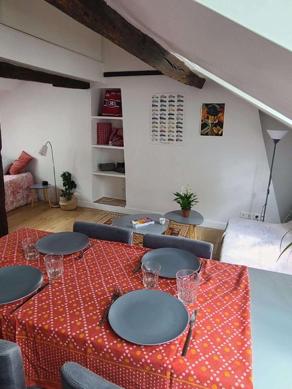 une table avec une nappe rouge et des chaises dans une pièce dans l'établissement Charmant studio Montparnasse, à Paris