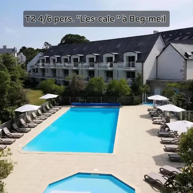 un hôtel avec une grande piscine et des chaises longues dans l'établissement L'ES-CALE DE BEG-MEIL AVEC PISCINE ET PLAGE Appartement avec 1 chambre et 1 alcôve, à Fouesnant