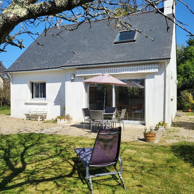 une chaise et un parasol devant une maison dans l'établissement FOUESNANT La Maison de Gigi, à 2 minutes de la plage de KERLER, à Fouesnant
