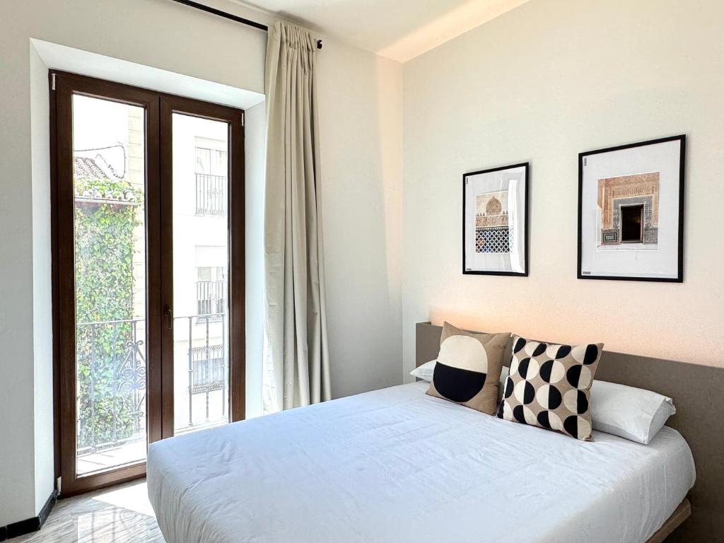 a bedroom with a bed and a large window at Casa Azhuma in Granada