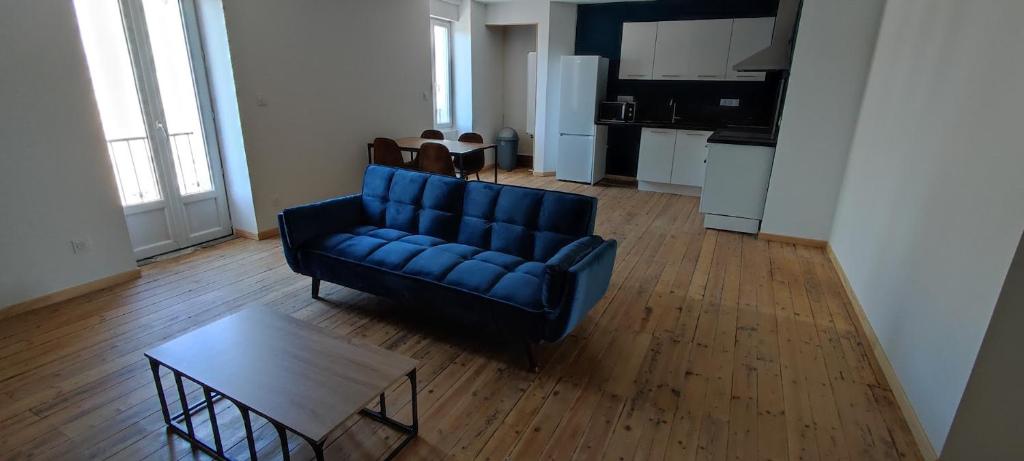 un salon avec un canapé bleu et une table dans l'établissement Appartement 3 chambres vallée du Lot, à Capdenac-Gare